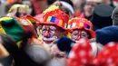 Dua badut mencoba melintas di mana puluhan ribu orang bersuka ria merayakan dimulainya musim karnaval di jalan-jalan Kota Cologne, Jerman, Senin (11/11/2019). Tradisi ini akan dimulai tepat pada jam 11.11, tanggal 11, dan bulan sebelas. (AP Photo/Martin Meissner)