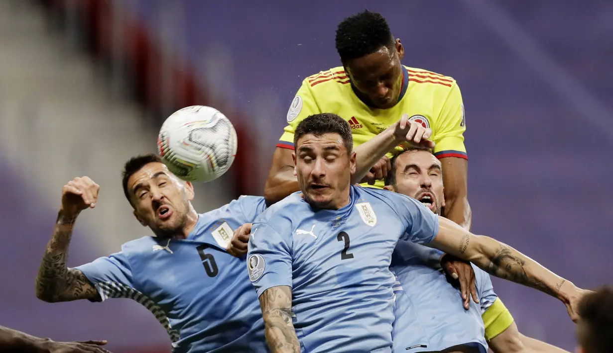 Pemain Kolombia, Oscar Murillo, duel udara dengan tiga pemain Uruguay pada laga perempat final Copa America 2021 di Stadion Nasional, Brasil, Minggu (4/5/2021). (Foto: AP/Bruna Prado)