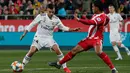 Gelandang Real Madrid Daniel Ceballos berebut bola dengan pemain Girona Douglas Luiz pada leg kedua perempat final Copa del Rey di Stadion Municipal de Montilivi, Kamis (31/1). Madrid melangkah ke semifinal Copa del Rey  dengan skor 3-1. (PAU BARRENA/AFP)