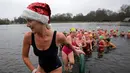 Sejumlah perenang naik meninggalkan danau usai mengikuti lomba berenang di Danau Serpentine di Hyde Park, London, Inggris, Minggu (25/12). Lomba ini digelar untuk merayakan Natal 2016. (REUTERS/Toby Melville)