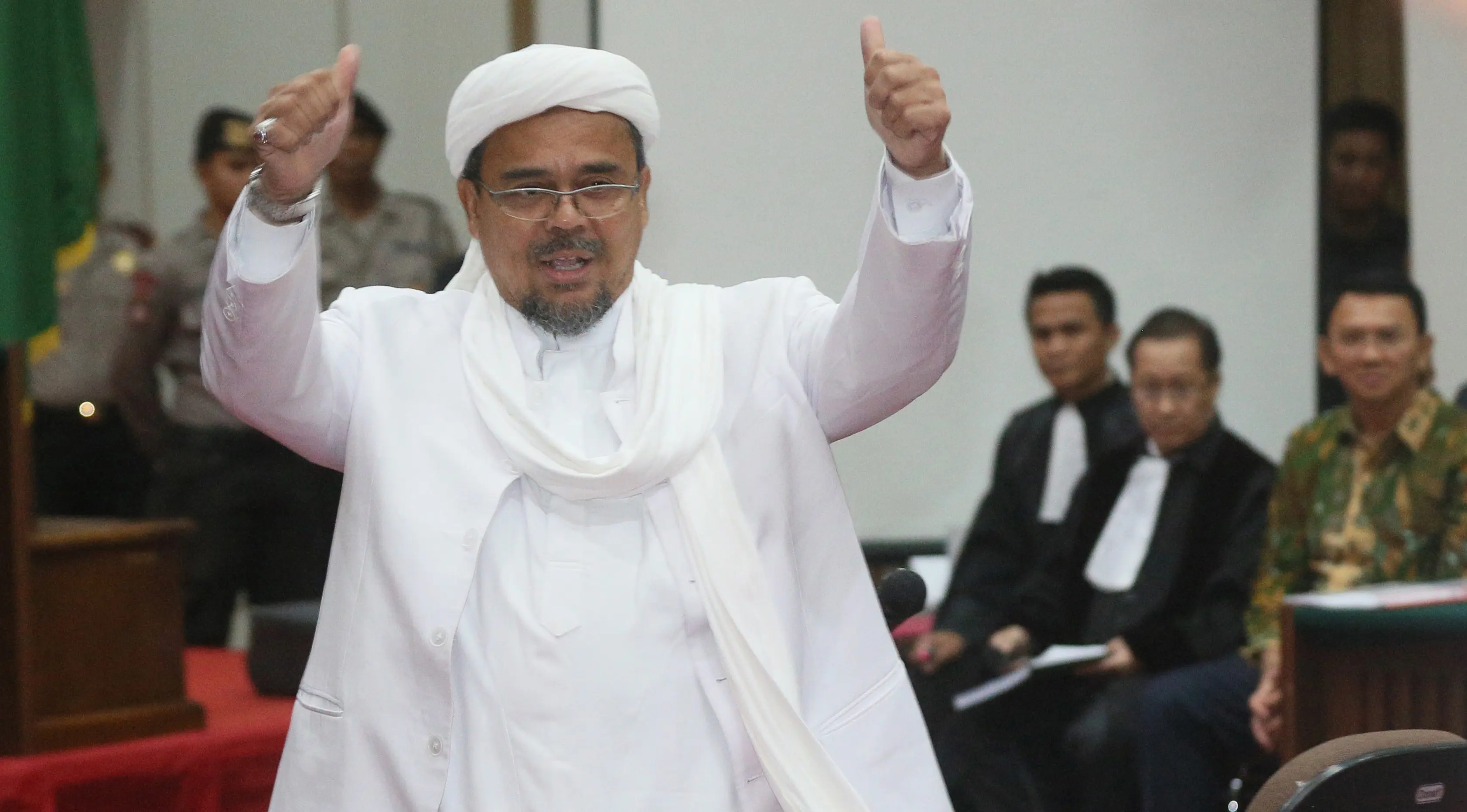 Pemimpin FPI Rizieq Shihab mengacungkan jempol saat memasuki ruang persidangan Auditorium Kementan, Jakarta, Selasa (28/2). Rizieq Shihab menjadi saksi ahli agama di sidang ke-12 terdakwa Basuki Tjahaja Purnama atau Ahok. (Liputan6.com/RAMDANI/Pool)