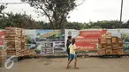 Warga berjalan diantara peti buah di samping lokasi pembangunan pusat perkulakan, Pasar Induk, Kramat Jati, Jakarta, Senin (16/1). Pemerintah Provinsi (Pemprov) DKI Jakarta berencana membangun pusat perkulakan di Kramat Jati. (Liputan6.com/Yoppy Renato)