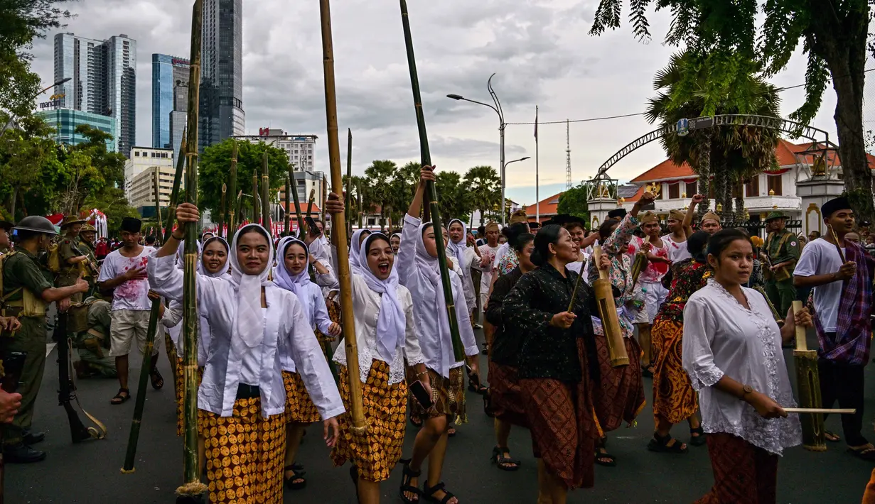 Anggota Komunitas Roode Brug Soerabaia dan Reenactor Indonesia berpartisipasi dalam reka ulang Pertempuran Surabaya, Minggu 2 November 2025. Melalui drama teatrikal ini, komunitas sejarah Roode Brug Soerabaia dan Reenactor Indonesia mengajak seluruh elemen bangsa Indonesia, khususnya pemuda Surabaya, untuk mengenang semangat perjuangan arek-arek yang gugur mempertahankan kemerdekaan. (Juni KRISWANTO/AFP)