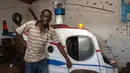 Felix Kambwiri berdiri di dekat helikopter buatannya di garasi rumahnya di Desa Gobede, Malawi, 19 Februari 2016. Helikopter yang dikerjakan sejak empat bulan lalu itu dibuat dari rongsokan besi tua dan fiberglass. (Amos Gumulira/AFP)