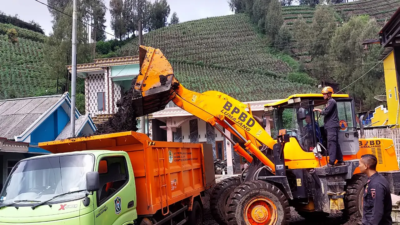 Proses pembersihan material lumpur di jalan raya Ranu Pani Lumajang. (Istimewa)