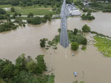 Sungai La Plata membanjiri jalan setelah Badai Tropis Ernesto melewati Toa Baja, Puerto Rico, Rabu (14/8/2024). (AP Photo/Alejandro Granadillo)