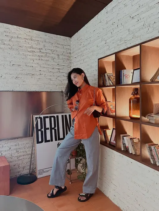 Selain hitam, baju oranye juga terlihat bagus dipadukan warna abu-abu. Ini membuat tampilan lebih kalem, tegas, dan cantik. [Instagram/alikaislamadina]