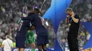 Pelatih PSG, Luis Enrique tengah mengatur posisi medalinya saat di atas podium setelah memastikan timnya menjuarai Liga Champions 2024/2025 dengan mengalahkan Inter Milan dalam laga final yang berlangsung di Allianz Arena, Munchen, Jerman, Minggu (01/06/2025) dini hari WIB. (AFP/Franck Fife)