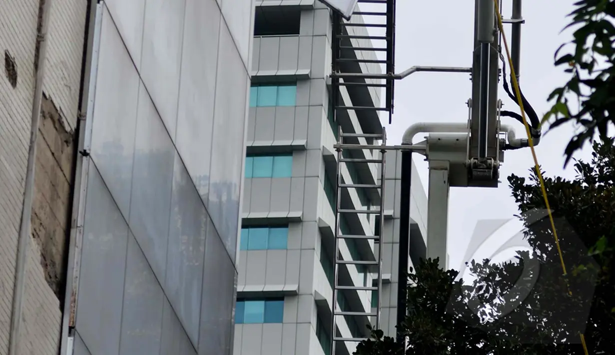 Petugas melepas plat aluminium pelapis dinding gedung Sekretariat Jenderal DPR RI yang roboh ditiup angin kencang di Kompleks Parlemen, Jakarta, Jumat (24/04/2015). Robohnya dinding karena usia gedung yang sudah lama. (Liputan6.com/Andrian M Tunay)
