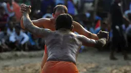 Pegulat saling mendorong saat mengikuti kompetisi gulat tradisional India yang diadakan di desa Rampur, India (7/10). Pegulat kushti biasa disebut pehlwan, sementara pelatih dipanggil Ustad (Pakistan) atau Guru (India). (AFP Photo/Sanjay Kanojia)