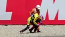 Pebalap Pons HP 40, Luis Salom, dibantu seorang marshall lomba setelah terjatuh dalam balapan Moto2 GP Spanyol di Sirkuit Catalunya, Barcelona, (15/6/2014). (AFP/Josep Lago)