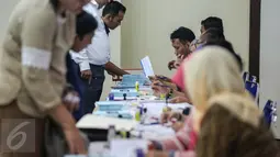 Sejumlah petugas sibuk melayani para calon peserta yang melakukan pendaftaran ujian profesi Perhimpunan Advokat Indonesia (Peradi) gelombang kedua di di Gedung Serbaguna Senayan, Jakarta, Senin (14/9/2015). (Liputan6.com/Faizal Fanani)