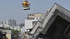 Lee Tsung-tien (42) diangkat dengan menggunakan crane oleh regu penyelamat di apartemen yang ambruk akibat gempa di kota Tainan, Taiwan, Senin (8/2). Dua korban berhasil diselamatkan setelah terperangkap selama lebih dari 50 jam. (AFP PHOTO/Sam Yeh)