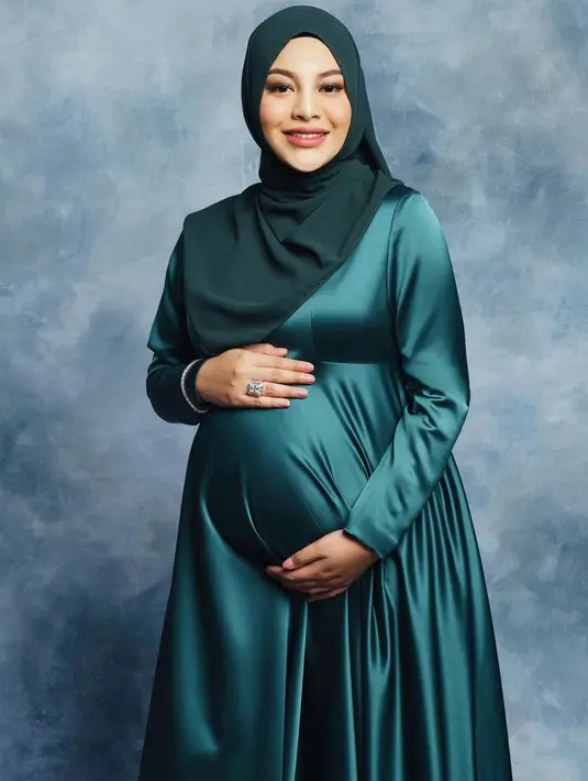 Sementara itu, saat maternity shoot anak pertamanya, Aurel tampak lebih simple. Ia mengenakan dress lengan panjang warna hijau. [@aurelie.hermansyah]