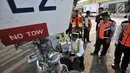 Menteri Perhubungan (Menhub) Budi Karya Sumadi mengecek roda pesawat saat meninjau pelayanan arus mudik di Bandara Halim Perdanakusuma, Jakarta, Senin (11/6). (Merdeka.com/Iqbal Nugroho)