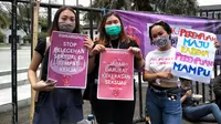 Sejumlah perempuan menunjukkan poster tentang menolak tindakan kekerasan terhadap perempuan dalam peringatan Hari Perempuan Internasional di depan Gedung Sate, Kota Bandung, Senin (8/3/2021). (Liputan6.com/Huyogo Simbolon)