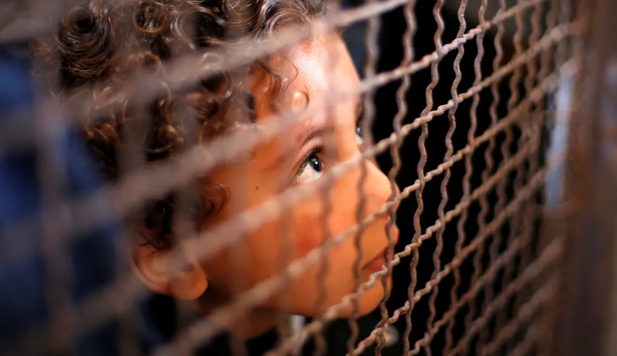 Seorang anak menunggu dengan keluarganya untuk izin perjalanan untuk menyeberang ke Mesir melalui perbatasan Rafah setelah dibuka selama dua hari oleh pemerintah Mesir, di selatan Jalur Gaza 11 Mei 2016. (REUTERS / Suhaib Salem)