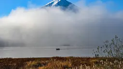 Pengunjung dapat menikmati keindahan Gunung Fuji dari berbagai sudut pandang di sekitarnya, seperti dari area Danau Kawaguchiko atau saat menaiki Shinkansen (kereta cepat) antara Tokyo dan Kyoto. Tampak dalam foto, Gunung Fuji, gunung tertinggi di Jepang dengan ketinggian 3.776 meter (12.460 kaki), terlihat dari kota Fujikawaguchiko, Prefektur Yamanashi pada Senin 17 November 2025 pagi hari. (Caroline GARDIN/AFP)