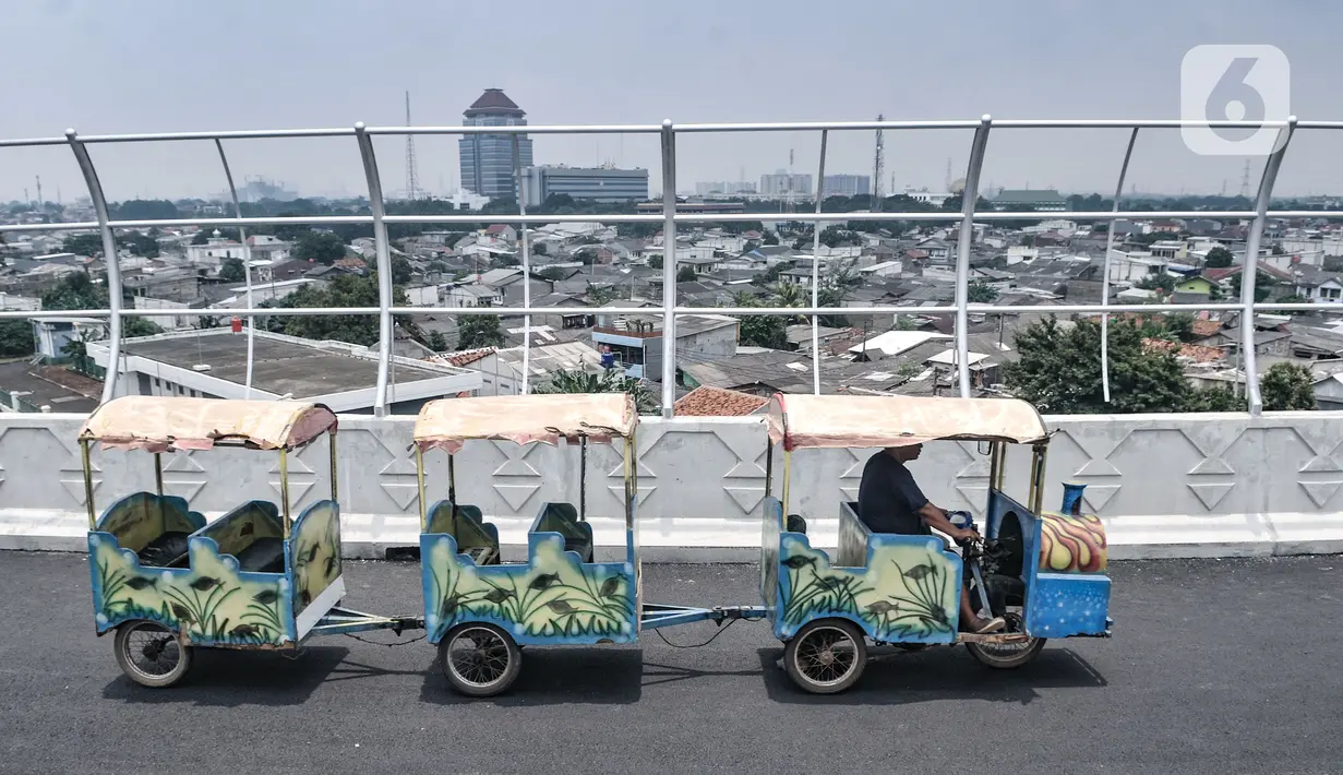 Odong-odong saat melintas di Flyover Cakung, Jakarta, Selasa (16/3/2021).  Progres pembangunan flyover yang menghubungkan kawasan Duren Sawit dengan Cakung tersebut saat ini telah mencapai 96,44 persen. (merdeka.com/Iqbal S. Nugroho)