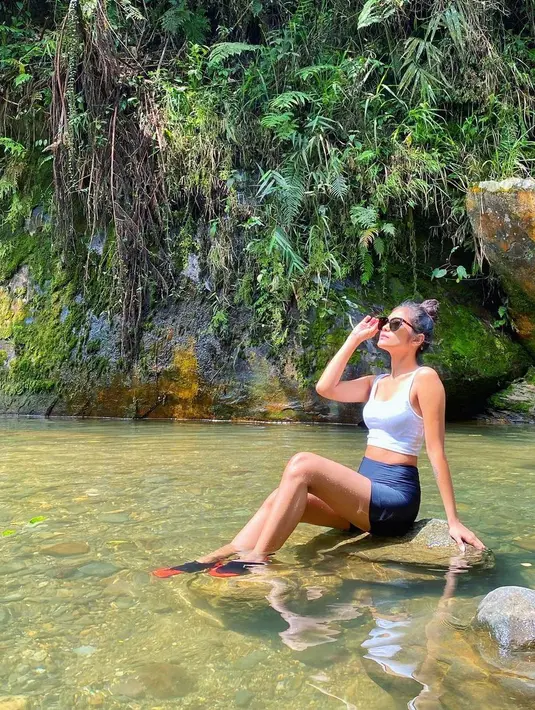 Sambil menikmati keindahan alam di sekitarnya, Garneta Haruni pun berpose dengan santai di area air terjun. Meski santai, gayanya tetap modis dan menawan.  (Liputan6.com/IG/@garnetaharuni).