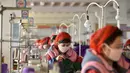 Pekerja Pabrik Pakaian Rajut Songyo membuat masker untuk perlindungan terhadap coronavirus baru di Pyongyang (6/2/2020). Setidaknya 31.000 orang telah terinfeksi dan lebih dari 630 orang meninggal akibat virus tersebut. (AFP/Kim Won-Jin)