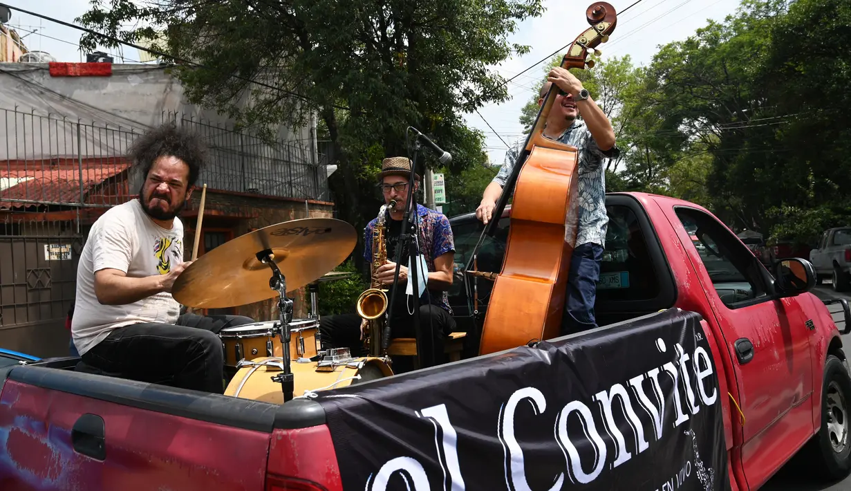 Band Maroto Jazz Trio yang terdiri dari Diego Maroto pada Saxophone, Jorge Molina pada double bass, dan Edy Vega pada drum tampil dari atas sebuah van melewati kawasan Mexico City, Meksiko, 29 Agustus 2020. Penampilan mereka dilakukan di tengah pandemi virus corona COVID-19. (RODRIGO ARANGUA/AFP)