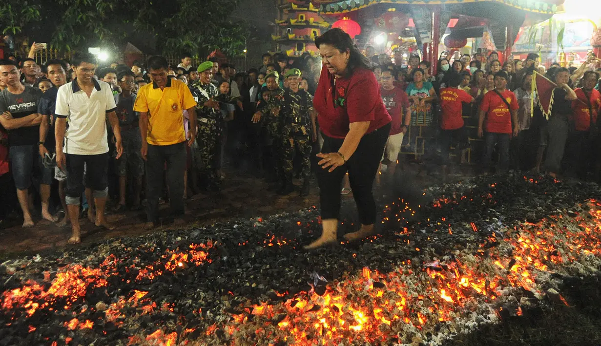 Warga melakukan atraksi Tahwe atau menginjak bara api di Hok Tek Bio Cibinong, Bogor, Sabtu (17/3). Ritual injak bara ini Ritual injak bara dimaksudkan sebagai upaya menolak bala untuk memohon keselamatan. (Merdeka.com/Arie Basuki)