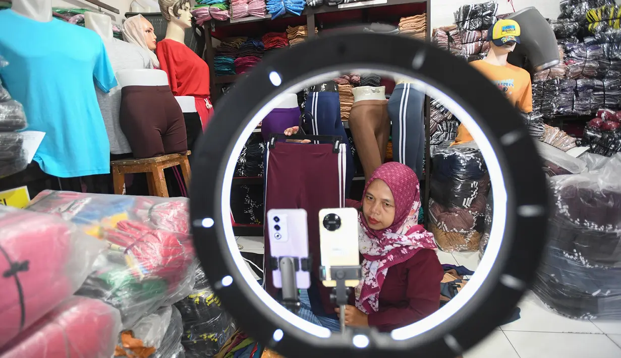Pekerja memasarkan secara live daring atau online produk konveksi di R. Clarisi Collection pada sentra Usaha Mikro Kecil dan Menengah (UMKM) Konveksi Bulak Timur, Depok, Jawa Barat, Senin, (17/3/2025). (merdeka.com/Arie Basuki)