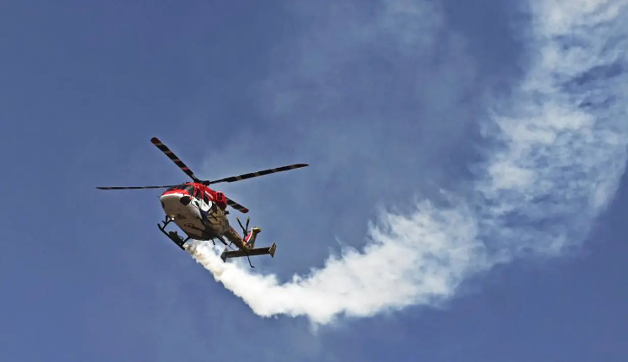 Tim akrobatik Advanced Light Helicopter Angkatan Udara India tampil pada hari pertama Aero India 2021 Airshow di Stasiun Angkatan Udara Yelahanka, Bangalore, India, Rabu (3/2/2021). Acara ini menampilkan pesawat dari AD, AL, AU, Hindustan Aeronautics, dan Coast Guard India. (Jewel SAMAD/AFP)