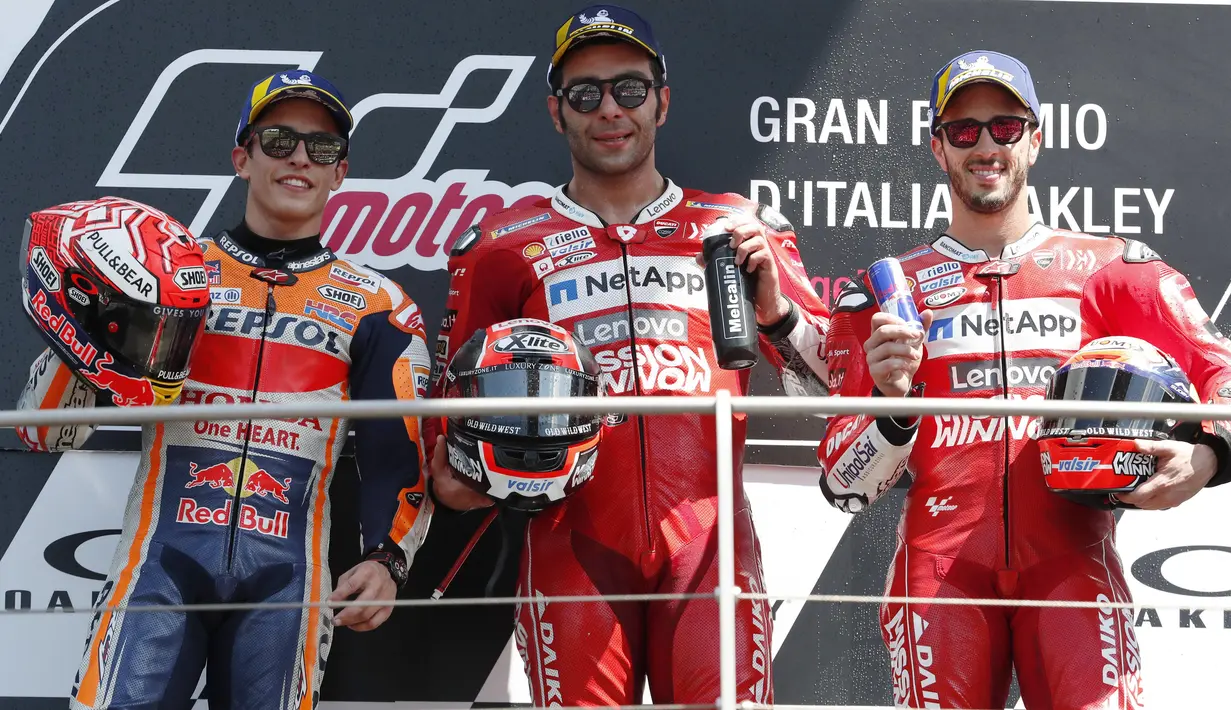 Pebalap Ducati, Danilo Petrucci, bersama Marc Marquez dan Andrea Dovizioso melakukan selebrasi usai menjuarai MotoGP Italia 2019 di Sirkuit Mugello, Minggu (2/6). Petrucci finis pertama dengan catatan waktu 41 menit 33,794 detik. (AP/Antonio Calanni)