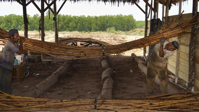 Pekerja memuat rotan untuk diekspor di sebuah bengkel di Banda Aceh (16/10/2019). Setiap tahunnya, Aceh mampu memproduksi sekitar ratusan ribu ton rotan. (AFP Photo/Chaideer Mahyuddin)