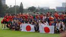 Sejumlah anak-anak yang tergabung ke dalam sekolah sepak bola Jakarta Japan Club (JJC) berfoto bersama dengan para pemain Timnas Jepang sebelum sesi latihan yang berlangsung di Lapangan A, Senayan, Jakarta, Selasa (12/11/2024). (Bola.com/Bagaskara Lazuardi)