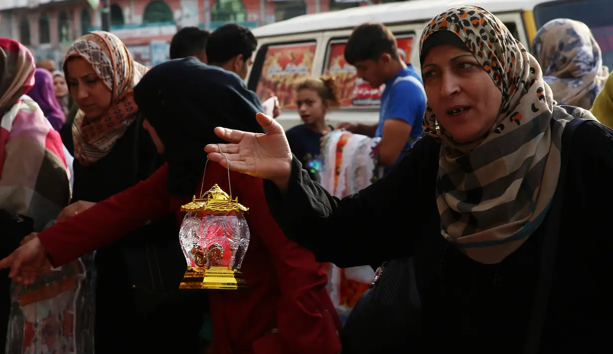 Seorang wanita menanyakan harga lentera Ramadan yang dijajakan salah satu kios di pasar Kota Gaza, Kamis (25/5). Warga Palestina merayakan datangnya bulan puasa dengan memasang lentera tradisional khas Ramadan sebagai dekorasi rumah. (AP Photo/Adel Hana)