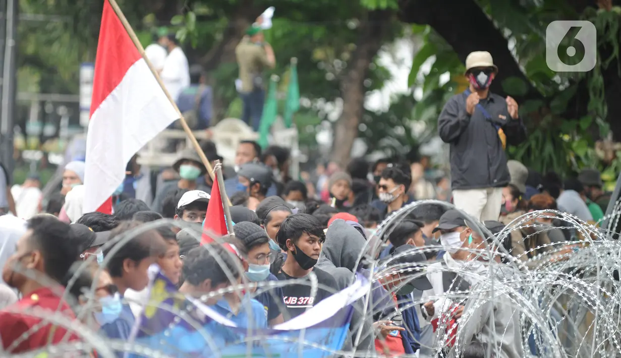 Massa aksi demo saat menolak Omnibus Law UU Cipta Kerja sekaligus refleksi satu tahun Pemerintahan Jokowi-Ma'ruf di kawasan Patung Kuda, Jakarta, Selasa (20/20/2020). Aksi ribuan pengunjuk rasa dari berbagai elemn berjalan aman. (merdeka.com/ Arie Basuki)