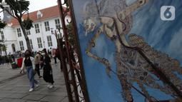 Pengunjung berjalan-jalan di kawasan wisata Kota Tua Jakarta, Minggu (4/4/2021). Libur panjang perayaan Paskah 2021 dimasa pemberlakuan PPKM Berskala mikro dimanfaatkan sejumlah warga untuk berwisata di kawasan Kota Tua Jakarta. (Liputan6.com/Helmi Fithriansyah)
