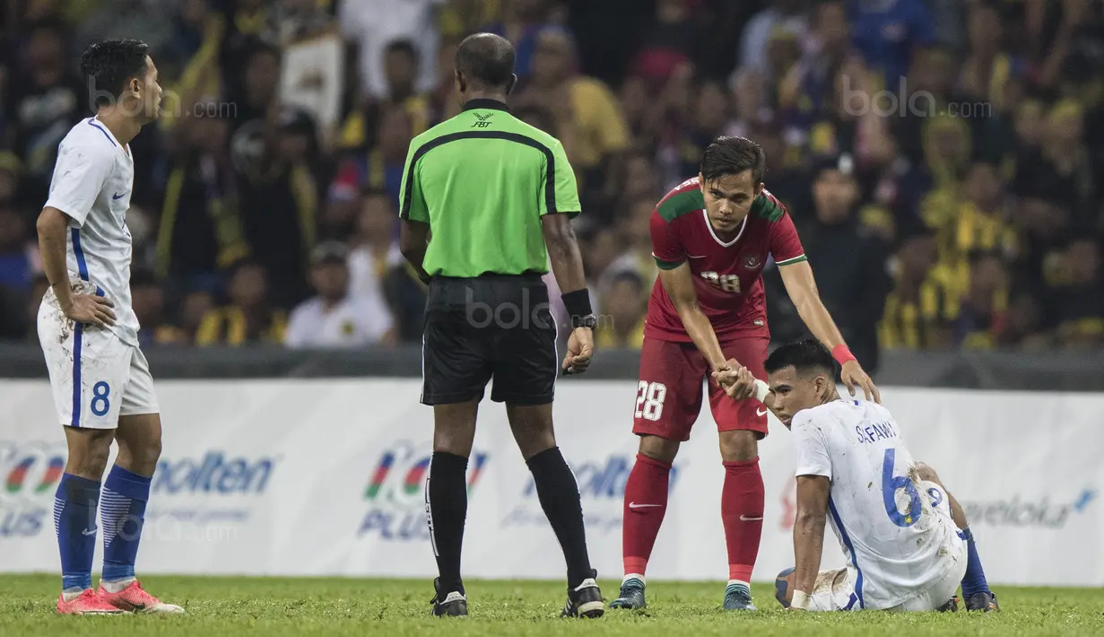 Bek Timnas Indonesia, Rezaldi Hehanusa, mengulurkan tangan membantu pemain Malaysia yang kesakitan saat laga semifinal SEA Games di Stadion Shah Alam, Selangor, Sabtu (26/8/2017). Indonesia kalah 0-1 dari Malaysia. (Bola.com/Vitalis Yogi Trisna)