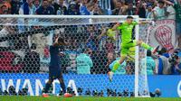 Kiper Argentina Emiliano Martinez melakukan selebrasi usai memblokir tendangan pemain Prancis Kingsley Coman dalam adu penalti pada pertandingan sepak bola final Piala Dunia 2022 di Stadion Lusail, Lusail, Qatar, 18 Desember 2022. Bermain imbang 3-3 selama 120 menit, Prancis akhirnya tumbang 2-4 dari Argentina dalam drama adu penalti. (AP Photo/Natacha Pisarenko)