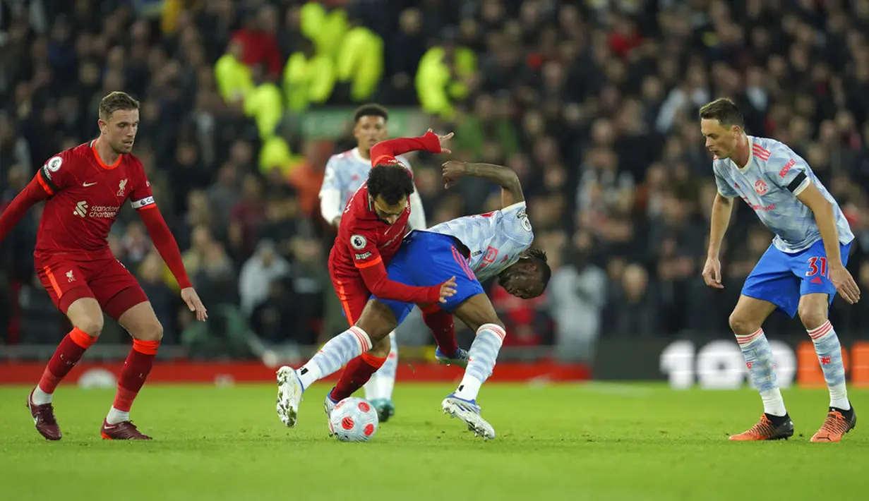 Pemain Manchester United Aaron Wan-Bissaka (tengah kanan) berebut bola dengan pemain Liverpool Mohamed Salah pada pertandingan sepak bola Liga Inggris di Stadion Anfield, Liverpool, Inggris, 19 April 2022. Liverpool menang 4-0. (AP Photo/Jon Super)