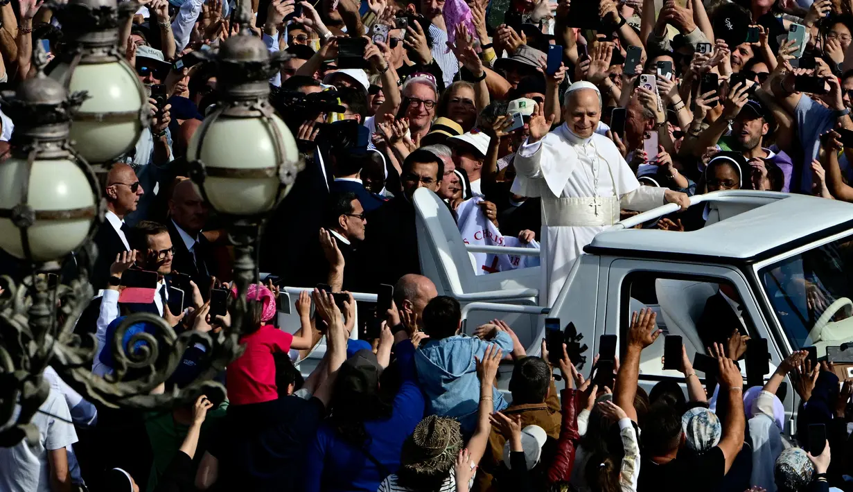 Ini menjadi yang perdana, Paus Leo XIV menaiki kendaraan kepausan "popemobile" jelang misa pelantikan yang akan digelar di Lapangan Santo Petrus Basilika di Vatikan, Minggu, 18 Mei 2025. (Tiziana FABI/AFP)