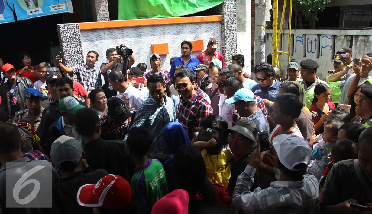 Ahok berjalan dikerumunan warga saat blusukan di Marunda, Cilincing, Jakarta, Rabu (2/1). Dalam blusukannya Ahok meminta warga untuk membangun Ruang Publik Terpadu Ramah Anak (RPTRA) di lingkungannya. (Liputan6.com/Gempur M. Surya)