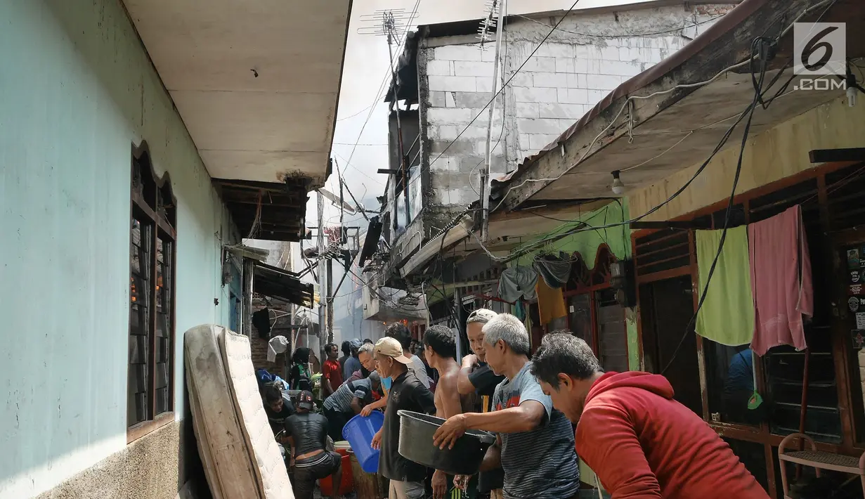 Sejumlah warga berusaha memadamkan api membakar pemukiman padat penduduk di kawasan Manggarai, Jakarta, Rabu (10/7/2019). Tidak ada laporan korban dalam kebakaran ini, sementara kerugian yang diderita masih dalam penanganan petugas di lokasi. (Liputan6.com/Herman Zakharia)