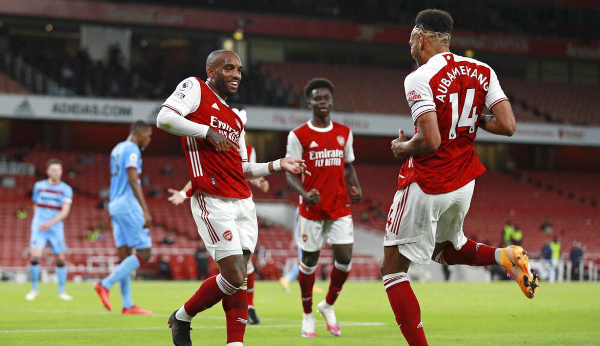 Pemain Arsenal, Alexandre Lacazette, melakukan selebrasi bersama Pierre-Emerick Aubameyang, usai membobol gawang West Ham United pada laga Premier League di Stadion Emirates, Sabtu (19/9/2020). Arsenal menang dengan skor 2-1. (AP/Ian Walton, Pool)