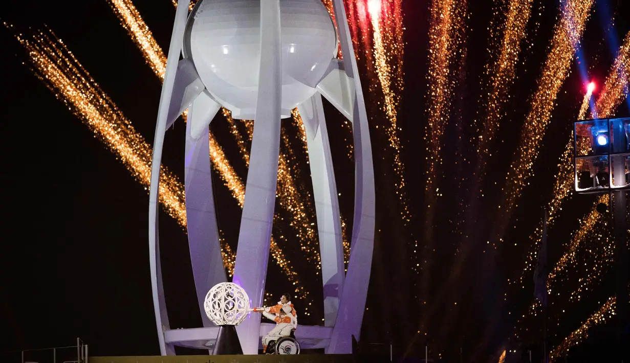 Seo Soon-Seok dan Kim Eun-jung dari Korea Selatan bersiap menyalakan Paralympic Cauldron dalam Upacara Pembukaan Paralympics 2018 di Stadion Olimpiade di Pyeongchang, Korea Selatan, (9/3). (Simon Bruty/OIS/IOC via AP)