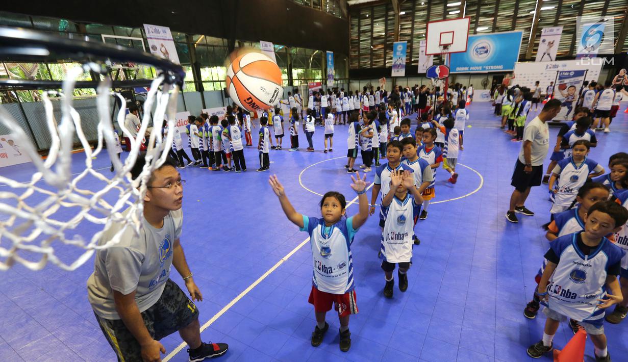 Anak-anak memasukan bola basket ke dalam keranjang pada program Junior NBA Indonesia di Cilandak, Jakarta, Sabtu (24/3). Peserta diberikan pelatihan tentang dasar-dasar olahraga basket. (Liputan6.com/Fery Pradolo)