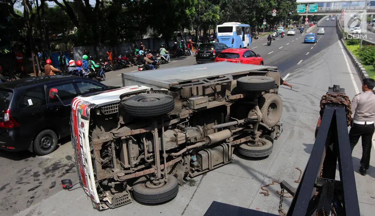 Sebuah mobil boks terguling di Jalan Casablanca, Jakarta, Rabu (27/6). Akibat kejadian tersebut, arus lalu lintas di sekitar Mal Kota Casablanka cukup padat dan tersendat. (Liputan6.com/Arya Manggala)