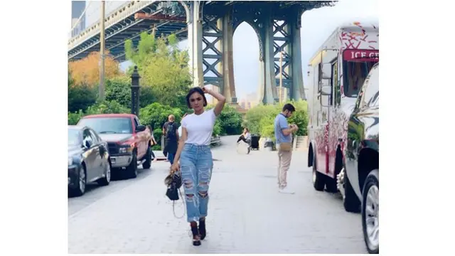 Yuni Shara memakai ripped jeans dan atasan kaos putih, simple dan keren.