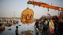 Sebuah patung raksasa dewi Durga diangkat menggunakan alat berat sebelum di tenggalamkan di sungai Yamuna selama festival Durga Puja di New Delhi, India (11/10). Ditenggelamkannya patung ini menandai berakhirnya festival Durga Puja. (AP Photo/Altaf Qadri)