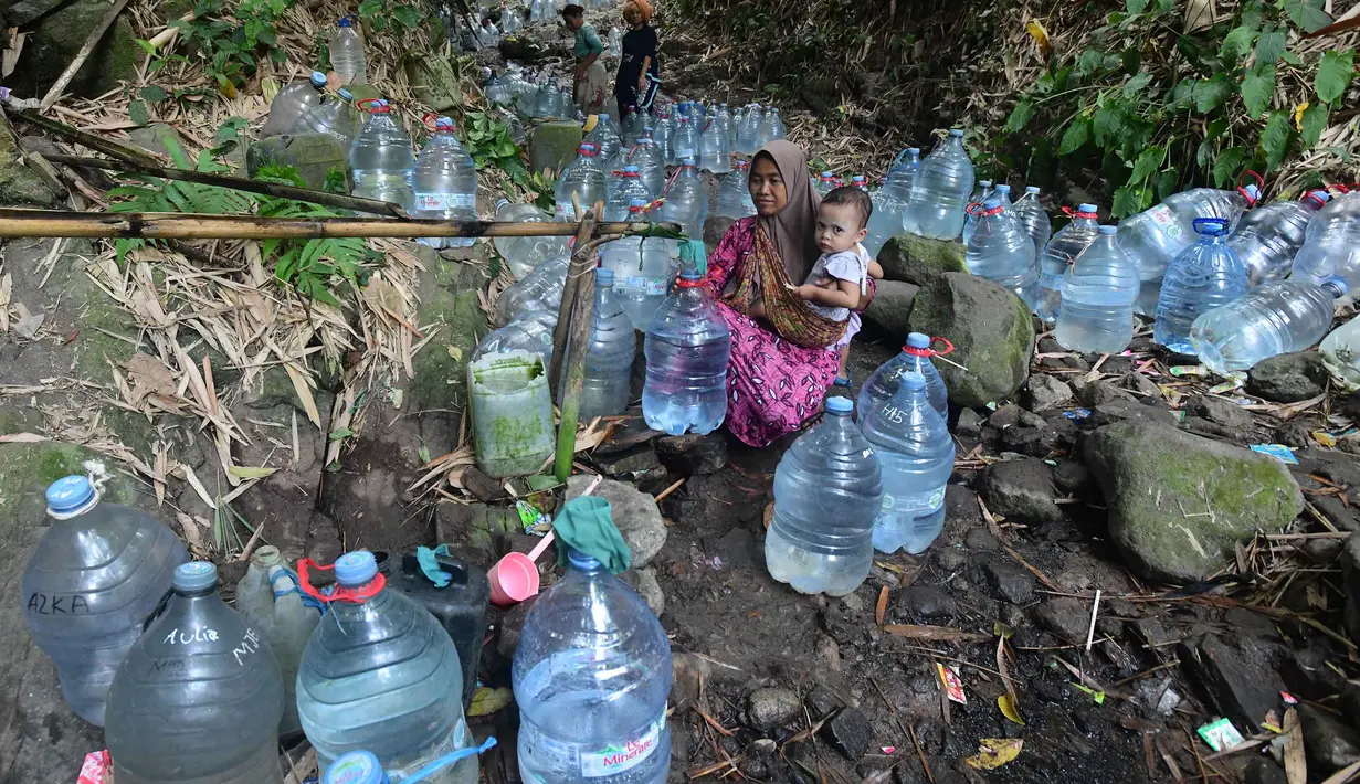 Warga  mengambil air untuk minum dan kebutuhan mck rumah  di sumber mata air Sumur Bendung, Gunung Batur, Kota Cilegon, Banten, Minggu, (15/7/2026). (KLY/Arie Basuki)