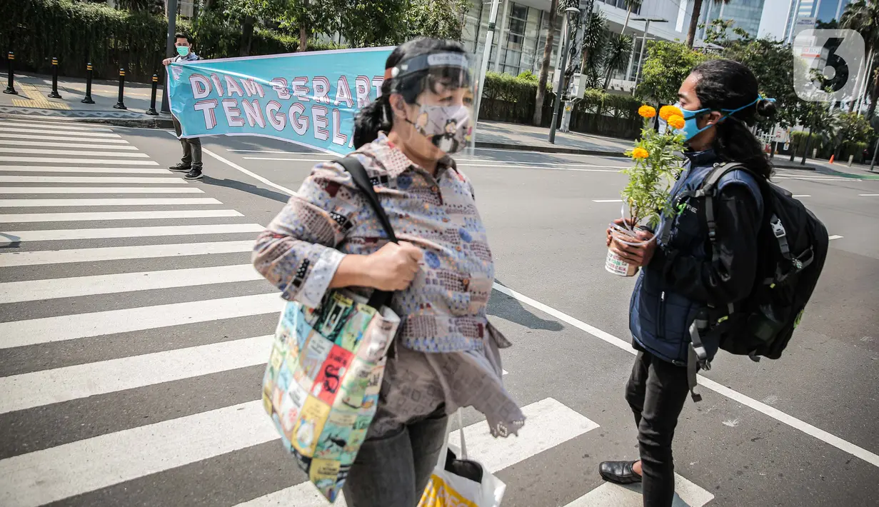 Aktivis lingkungan hidup menggelar aksi serempak Joget Jagat: Diam Berarti Tenggelam di Jakarta, Kamis (22/4/2021). Aksi untuk memperingati Hari Bumi serta menunjukkan semangat anak muda yang tidak tinggal diam dan tetap memperjuangkan hidup di tengah krisis iklim. (Liputan6.com/Faizal Fanani)