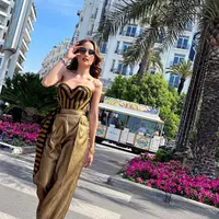 Berzodiak Leo, Cinta Laura kerap tampil fashionable dengan paduan bustier yang apik. Salah satunya saat memadukan bustier beraksen lurik dengan celana palazo keemasan. [@claurakiehl]